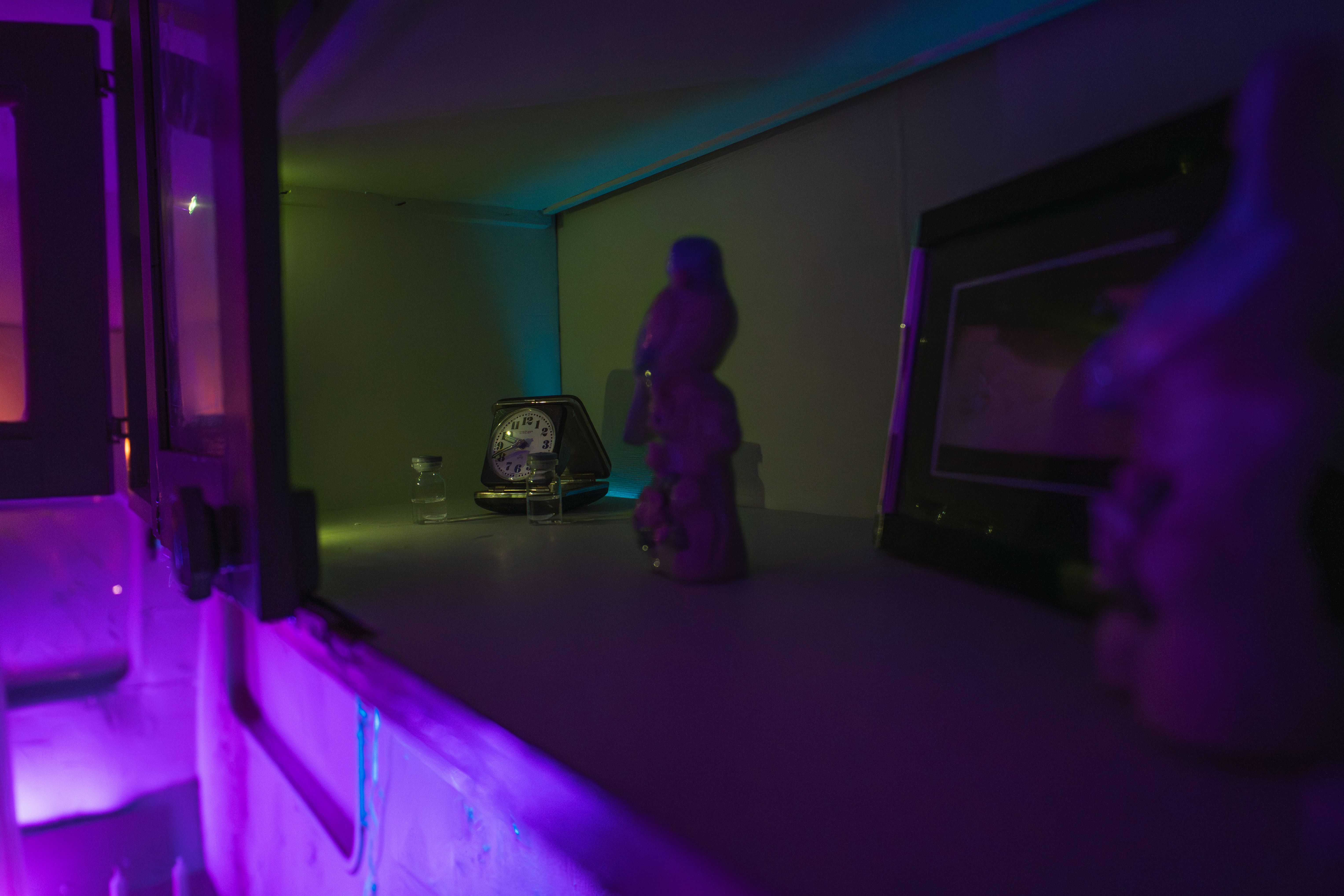 Small interior caravan shelf with clock and objects in purple light from L.E.O.N.