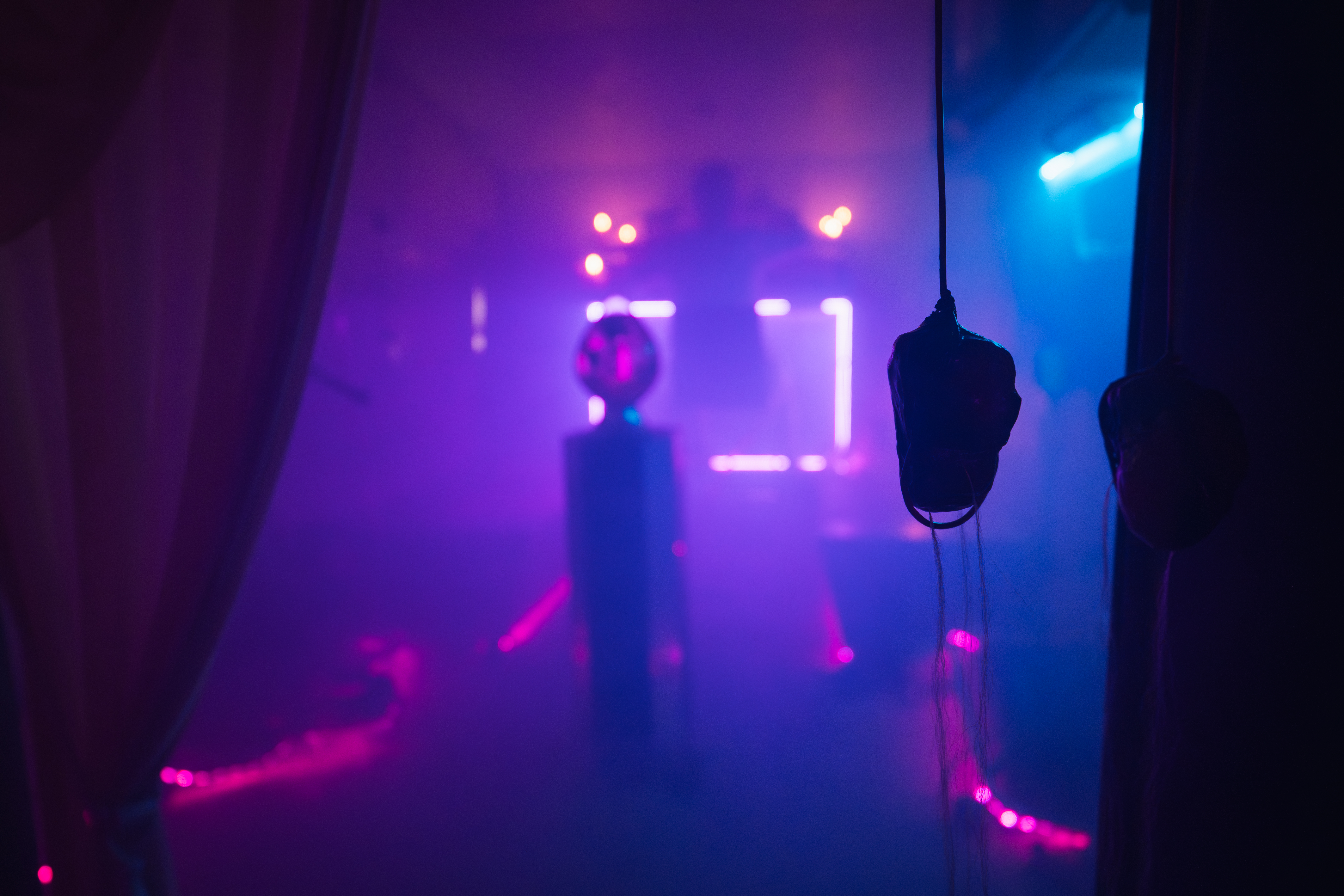 Purple and blue installation space with suspended dark objects from L.E.O.N.