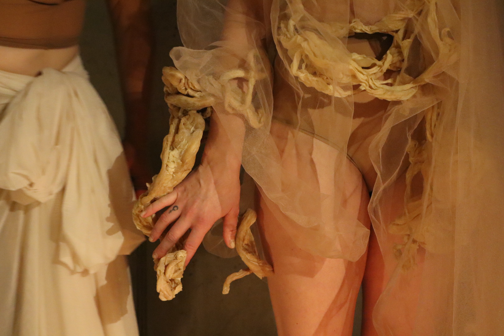 Close view of a performer wearing sculptural fabric in Midnight Mass