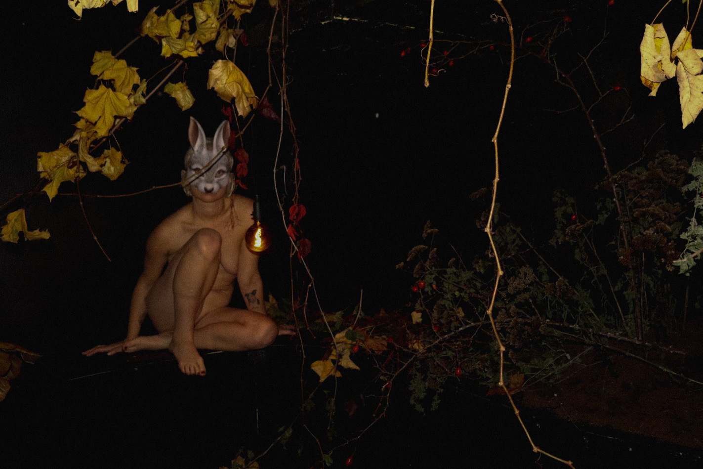 Masked figure in a dark installation environment for Prey for Me