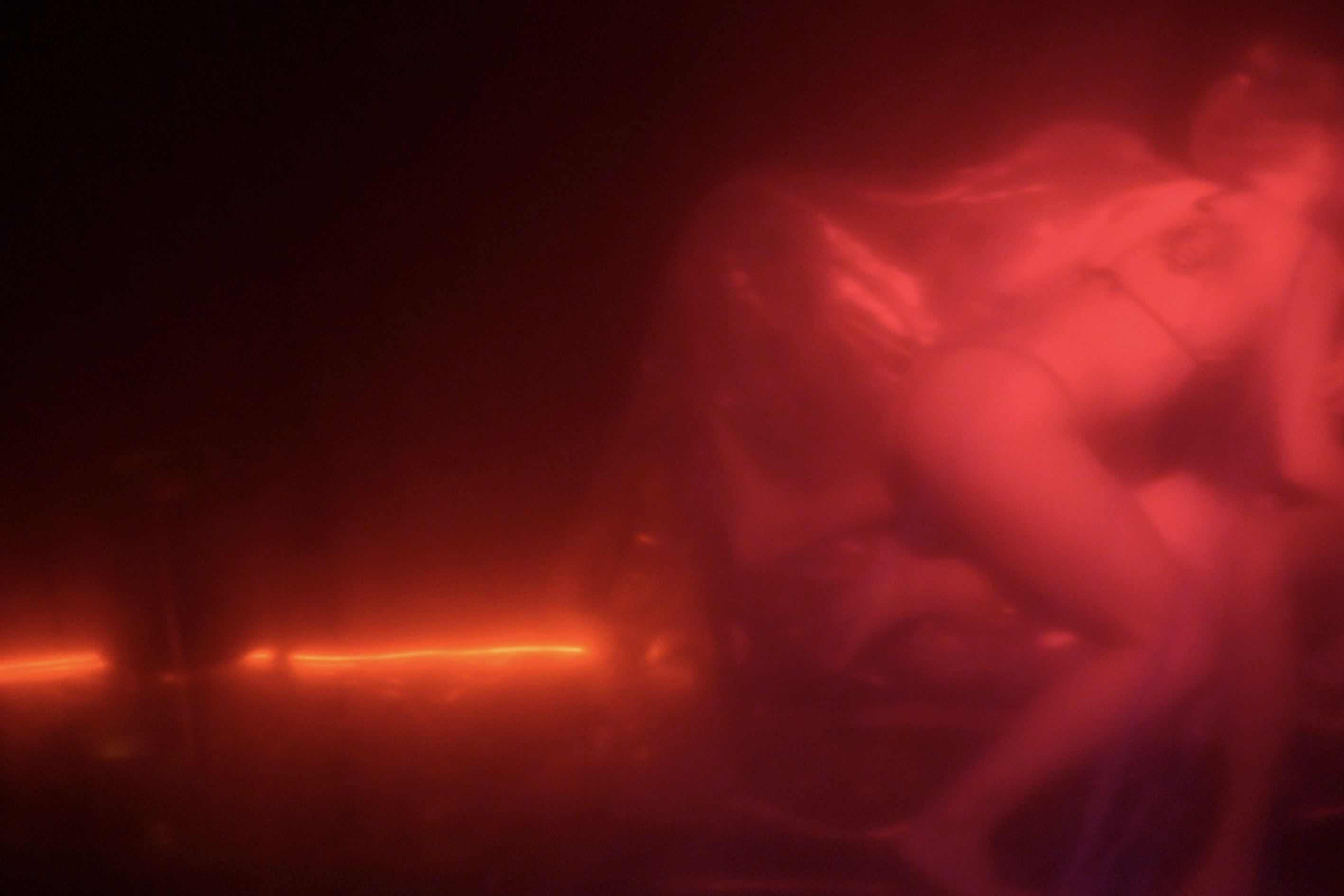 Two performers moving through red haze in The Roost Social Club
